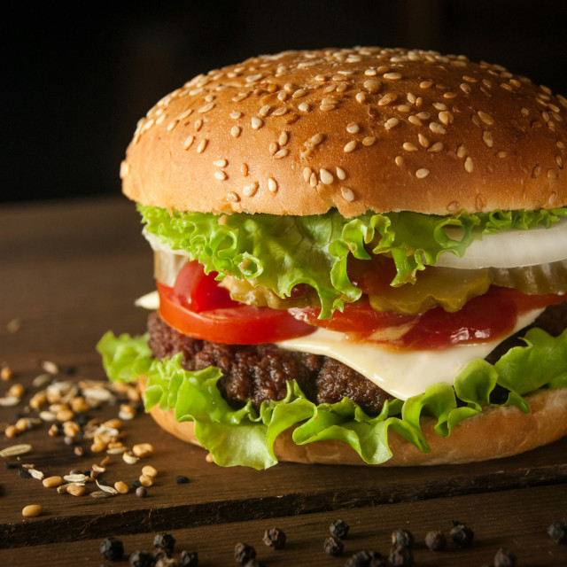 Burger wołowy z cheddarem i cebulą w bułce brioche